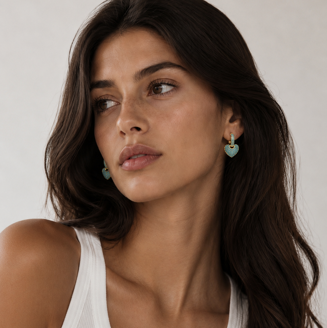 Woman wearing Lady Lou Collections heart-shaped earrings against a neutral background