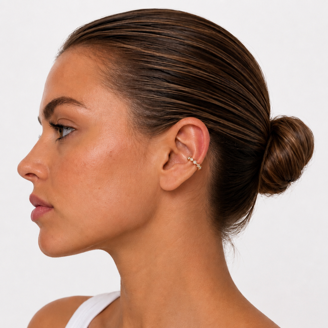 Model wearing gold plated ear cuff on white background