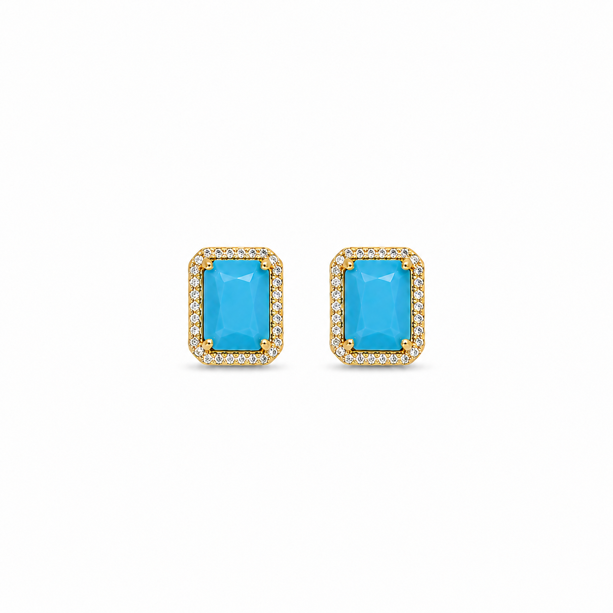 Pair of earrings with blue gemstones and gold frames on a white background