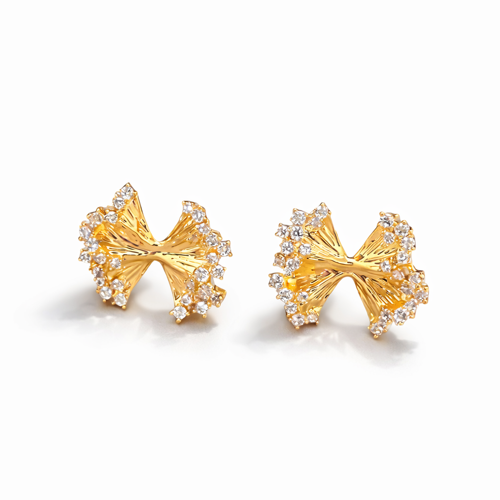 Gold plated bow-shaped earrings with embedded stones on a white background