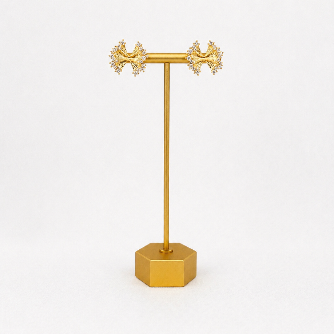 Gold plated bow earring with CZ stand on a white background