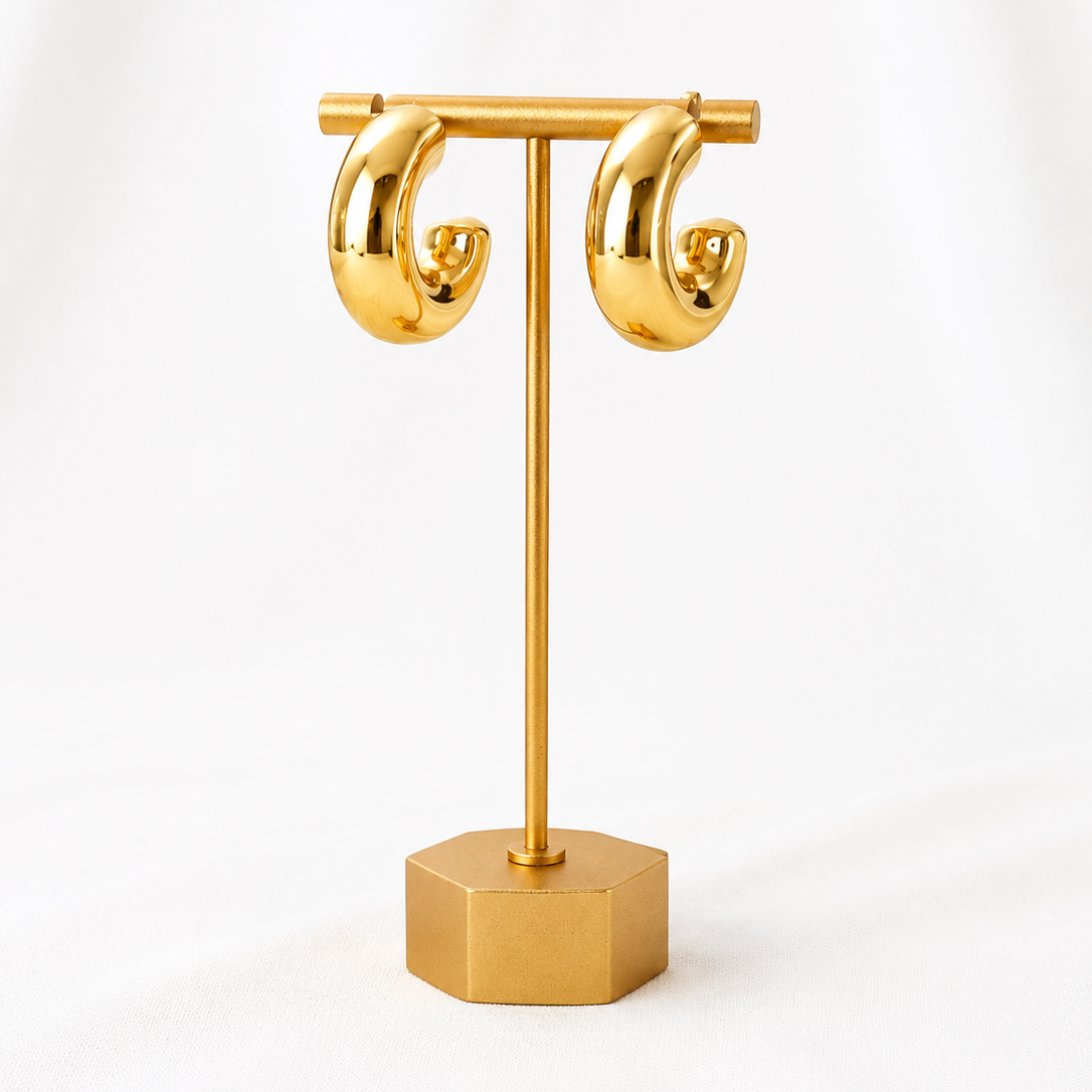 Gold plated Lady Lou Collections earring stand with two gold hoop earrings on a white background