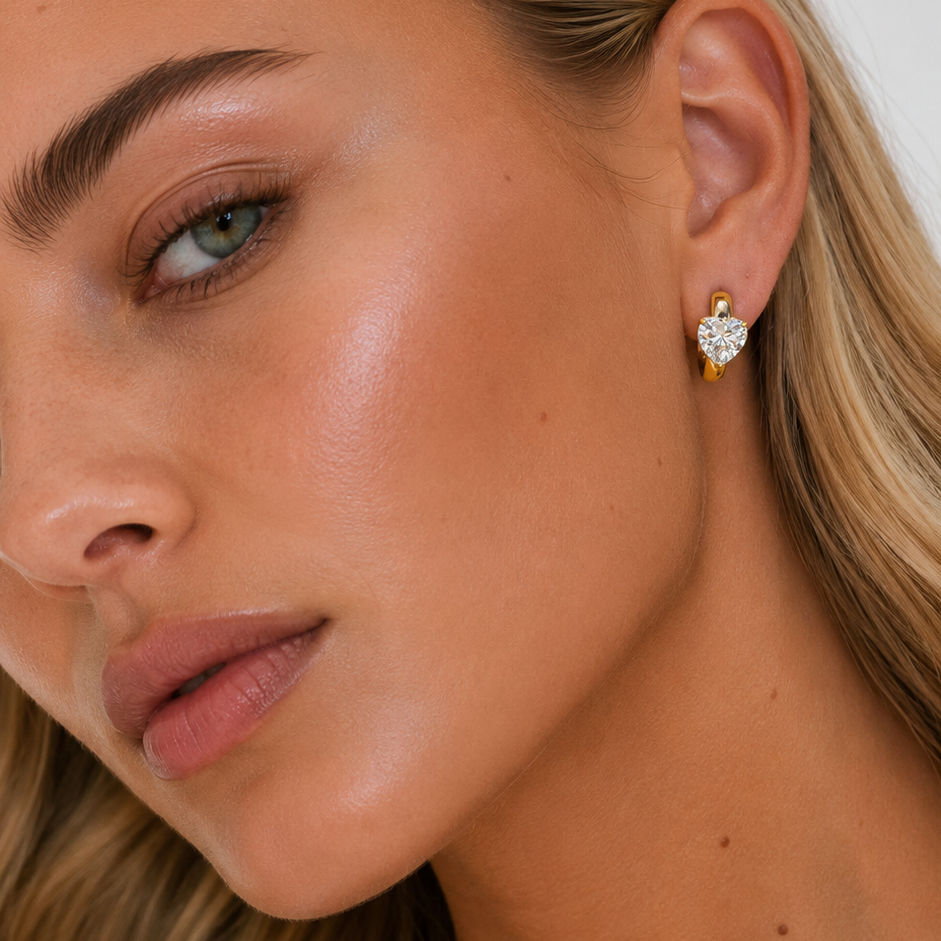 Close-up of a woman wearing gold earrings with a white background