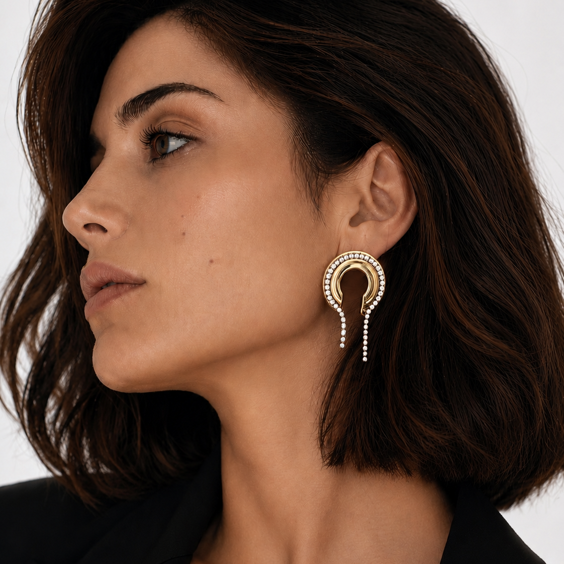Close-up of a woman wearing a gold plated Lady Lou Collection earring with CZ on a white background