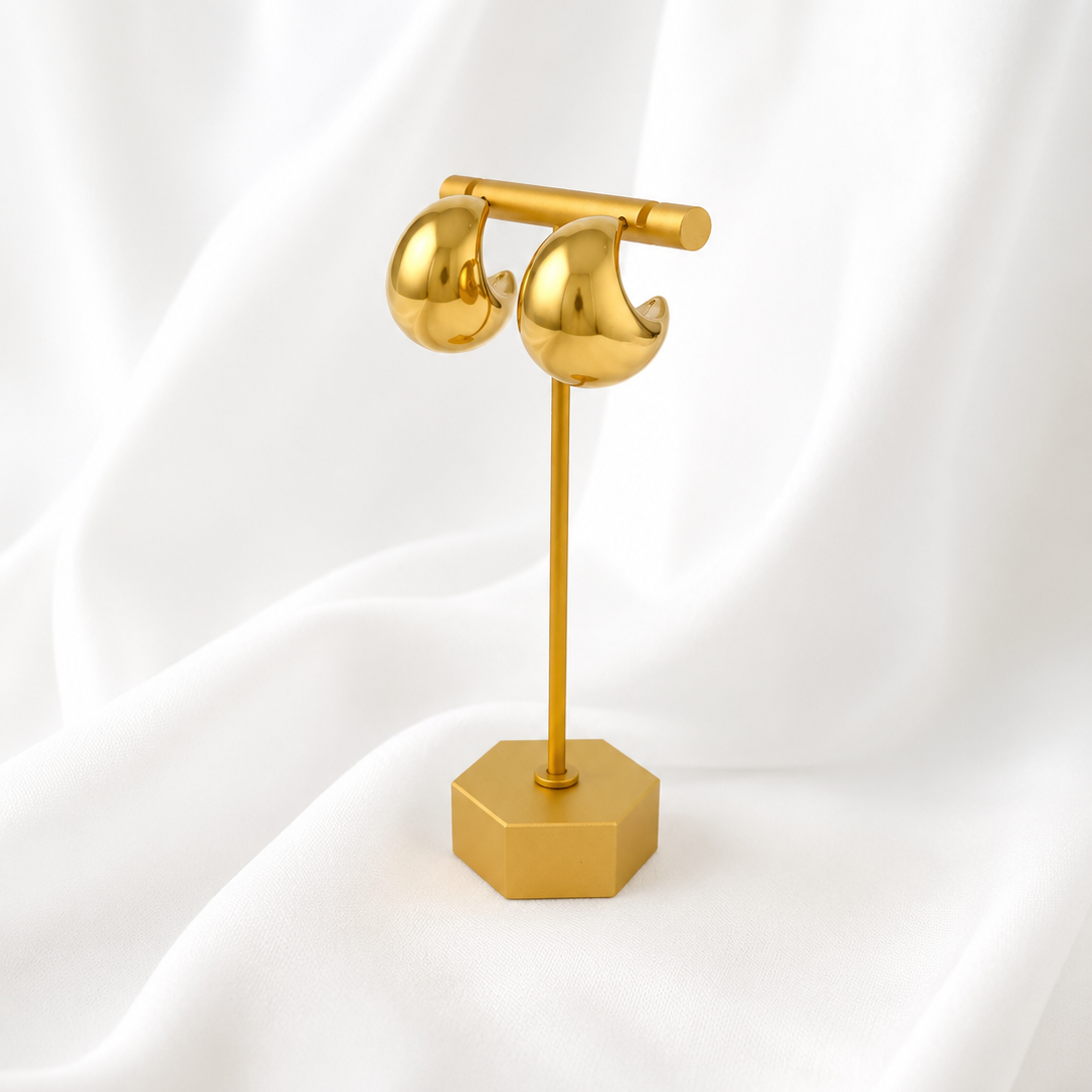 Gold plated Harper earring stand on a white fabric background
