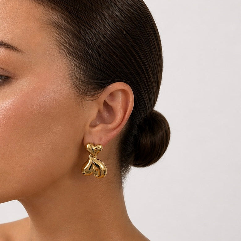 Gold Maggie heart drop earrings on model side profile