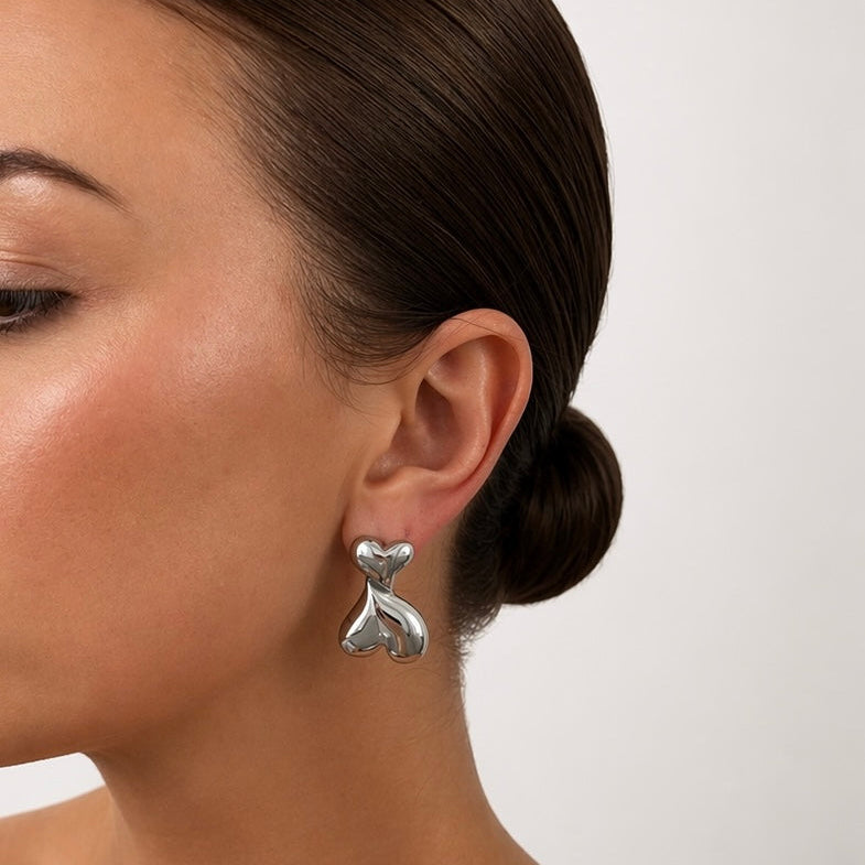 Silver Maggie heart drop earrings on model side profile
