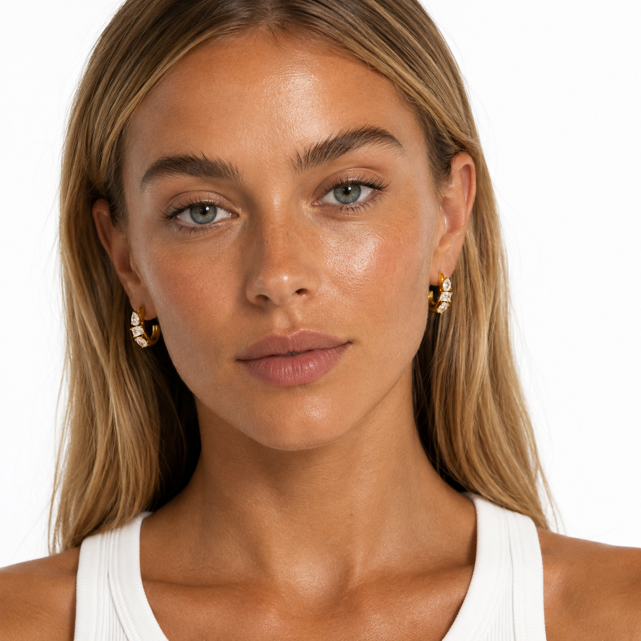 Model wearing a  pair of gold plated crescent-shaped hoop earrings adorned with marquise-cut clear CZ, displayed on a clean white background.