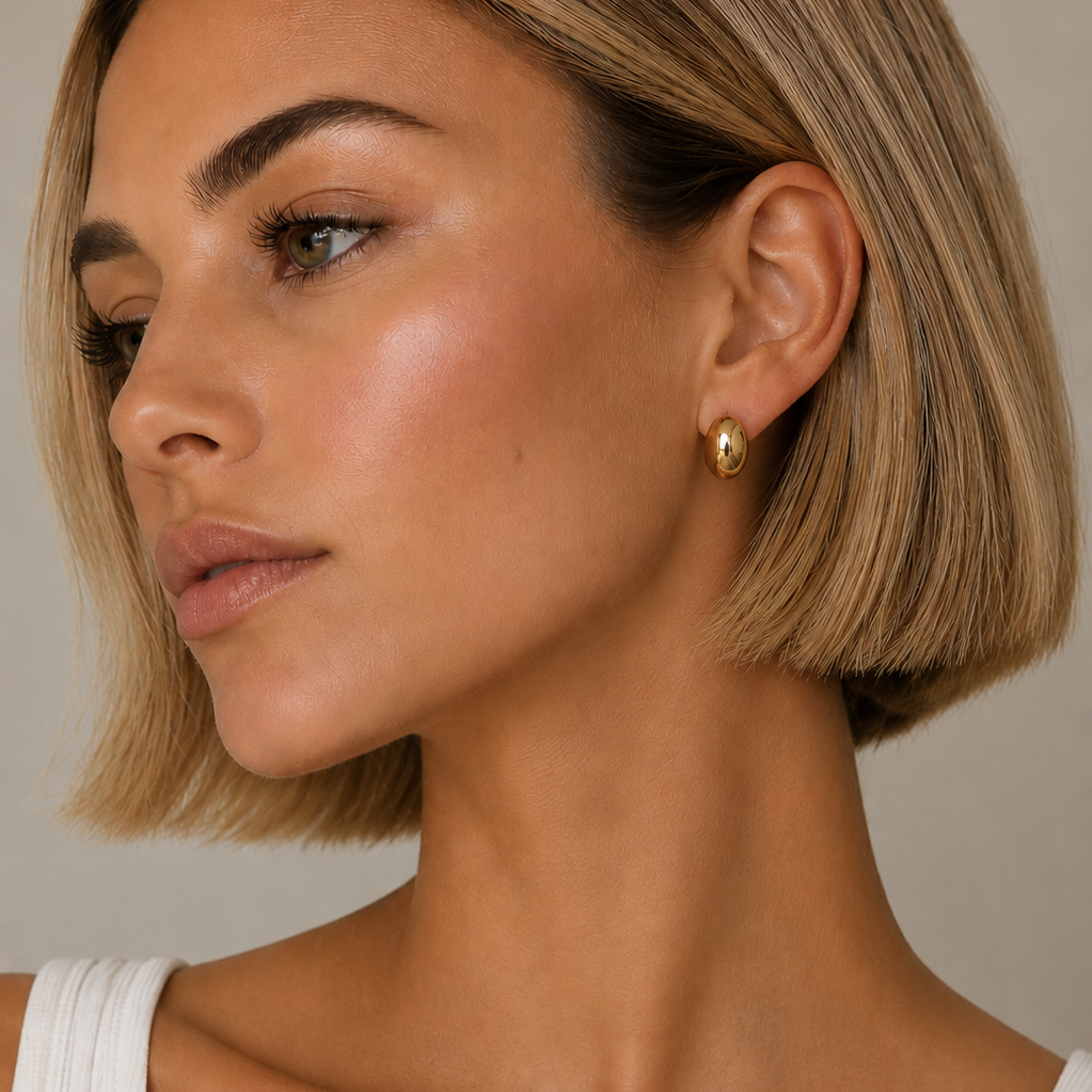 Close-up of a woman with a short blonde bob haircut wearing a gold plated Lady Lou Collections earrings.