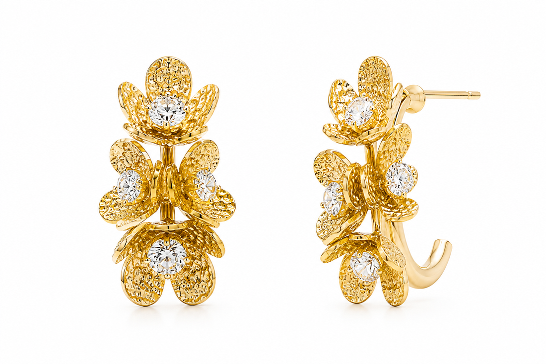 A pair of gold floral hoop earrings with textured petals and clear round-cut gemstones, shown on a plain white background with one earring facing forward and the other angled to show the post and hook.