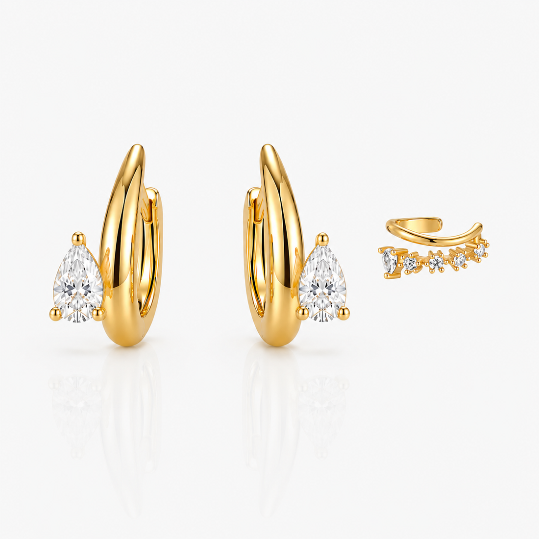 Set of gold earrings with diamond accents on a white background