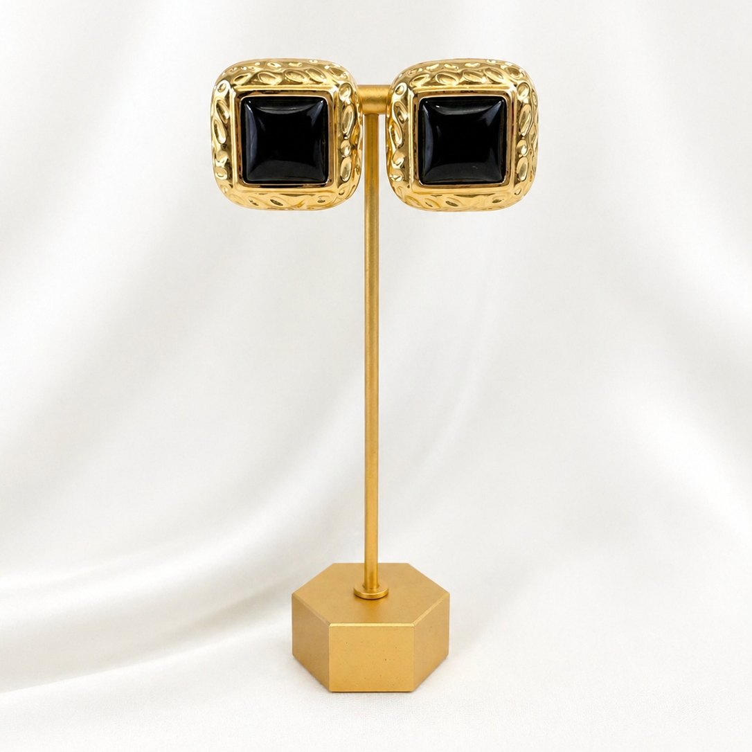 Zarie gold and black stud earrings displayed on stand